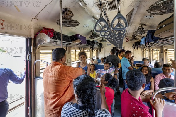 Travelers in the train compartment talking, relaxed scenery, everyday travel, train ride in a wagon in Sri Lanka