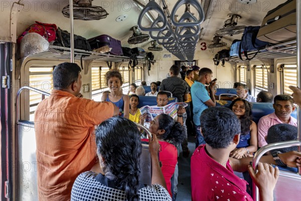 Passengers in a full train compartment, relaxed atmosphere, people talking and sitting, train ride in a wagon in Sri Lanka