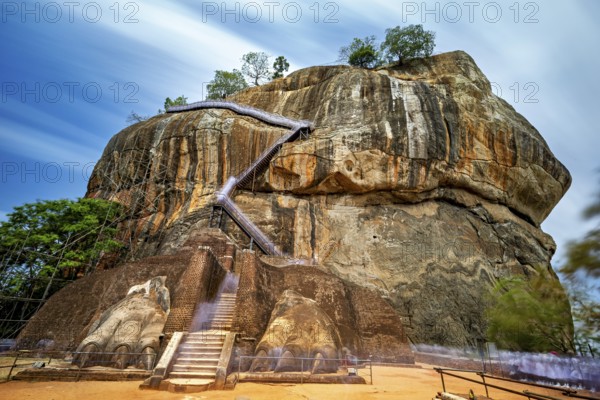 An impressive staircase on a large rock under clouds of rays, The Lion Rock near Sigiriya in Sri Lanka