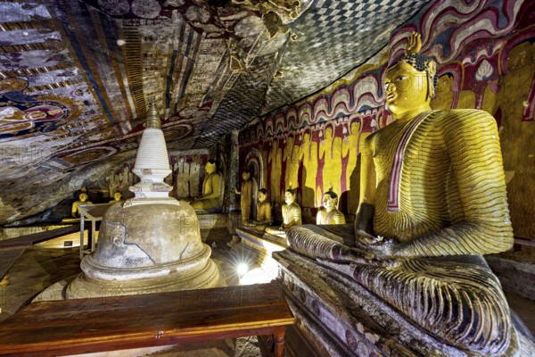 Cave with several Buddha statues and wall paintings, central stupa in a spiritual setting, The cave temples of Dambulla in Sri Lanka