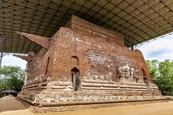 Large antique brick building under a modern roof structure, The temples of Polonnaruwa in Sri Lanka