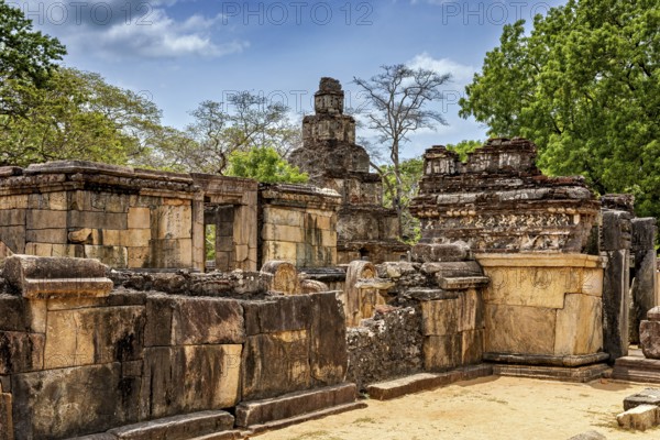 Historic stone ruins with surrounding trees and blue sky as a backdrop, The temples of Polonnaruwa in Sri Lanka