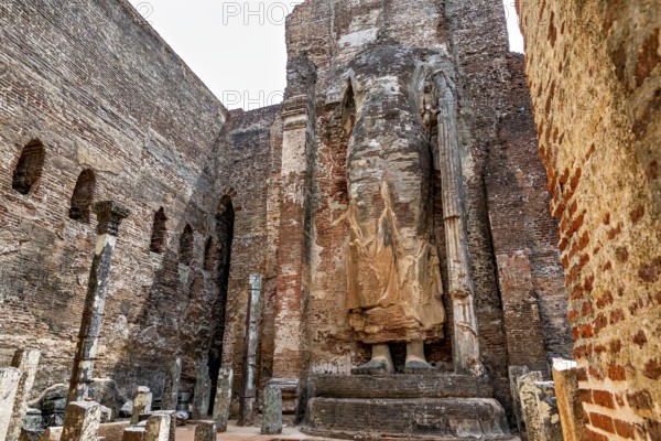 Large standing statue surrounded by ruins of old brick walls, The Temples of Polonnaruwa in Sri Lanka