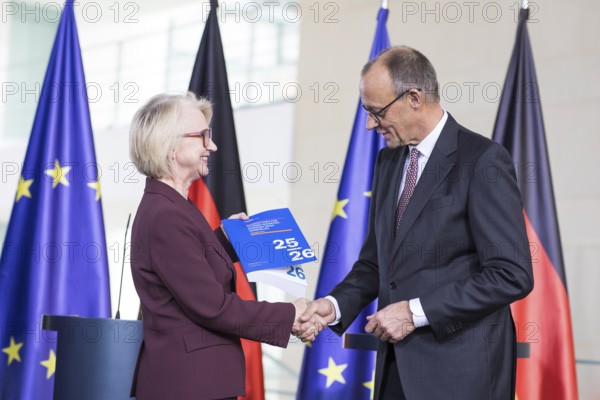 Prof. Dr. Monika Schnitzer (Chair of the Council of Experts) and Friedrich Merz (Federal Chancellor of the Federal Republic of Germany, CDU) handing over the 2025/2026 annual report entitled Creating prospects for tomorrow - do not squander opportunities from the Council of Experts to review macroeconomic development in the Federal Chancellery on 12.11.2025