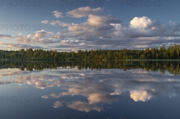 Clouds reflected on the water surface, forest lake, evening mood, at Sunne, Sweden
