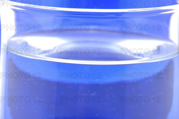 Glass with mineral water, small carbonated pearls on the edge of the glass, drinking water