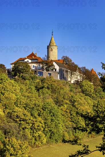 A castle with a tower, highlighted by colorful autumn trees and clear skies, The Leuchtenburg near Kahla im Saale Holzlandkreis in Thuringia