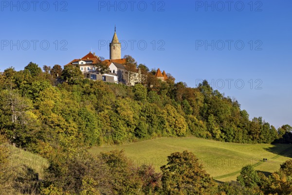 A castle in a hilly wooded area, surrounded by autumn landscape and blue skies, The Leuchtenburg near Kahla in the Saale Holzlandkreis district in Thuringia