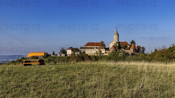 A castle on a hill with a wide meadow in the foreground and clear blue sky, The Leuchtenburg near Kahla im Saale Holzlandkreis in Thuringia