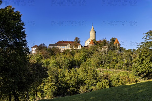 A castle on a wooded hill with clear blue sky in the background, The Leuchtenburg near Kahla im Saale Holzlandkreis in Thuringia