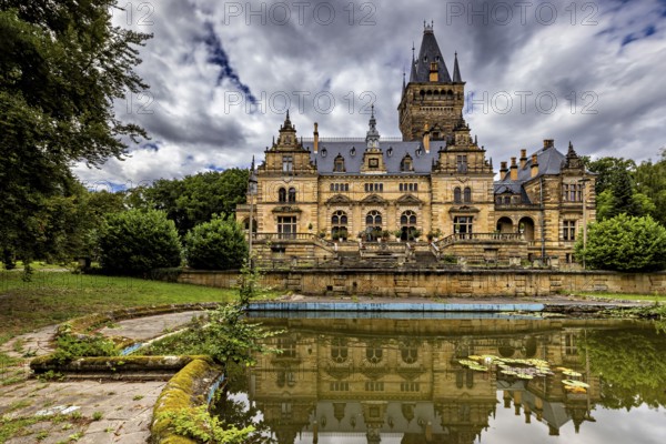 Castle with dramatic architecture reflected in a quiet pond surrounded by nature, The Hummelshain hunting lodge in Thuringia