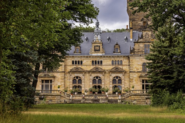 Castle hidden behind trees with a view of a green meadow, The Hummelshain hunting lodge in Thuringia