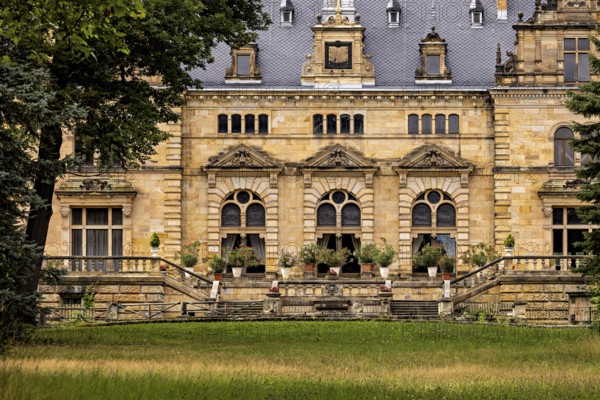 Historic castle façade with decorative windows and a lawn in front of it, The Hummelshain hunting lodge in Thuringia