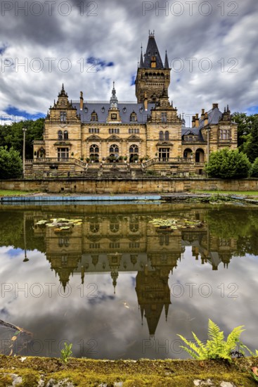 Magnificent castle with mirror lake and dramatic sky in the background, Hummelshain hunting lodge in Thuringia