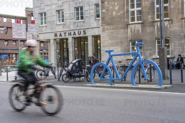 Bicycle parking spaces, with so-called leaning bars and a large blue bicycle silhouette, to make parking spaces visible at Bochum City Hall, North Rhine-Westphalia, Germany