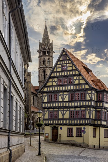 Historic alley with half-timbered house and church tower, dramatic cloud formations in the sky, the old town of Arnstadt in Thuringia