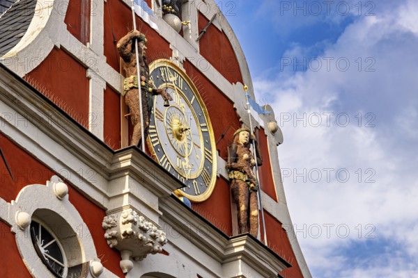 Baroque façade with clock and figures under a blue sky with clouds, The old town of Arnstadt in Thuringia