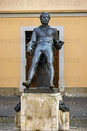 Bronze statue of a man in front of a façade in autumn, Johann Sebastian Bach monument in the old town of Arnstadt in Thuringia