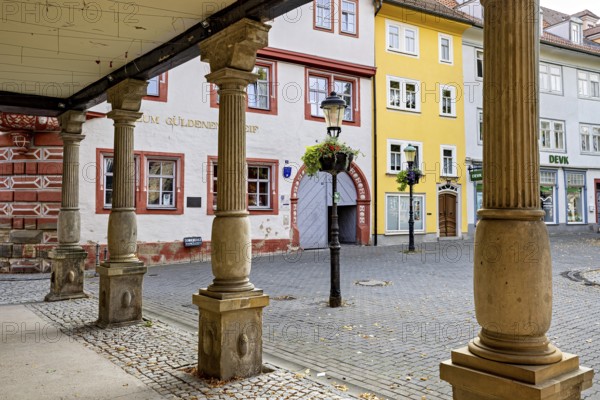 Columns in the city center surrounded by brightly painted historic buildings on cobblestones, The old town of Arnstadt in Thuringia