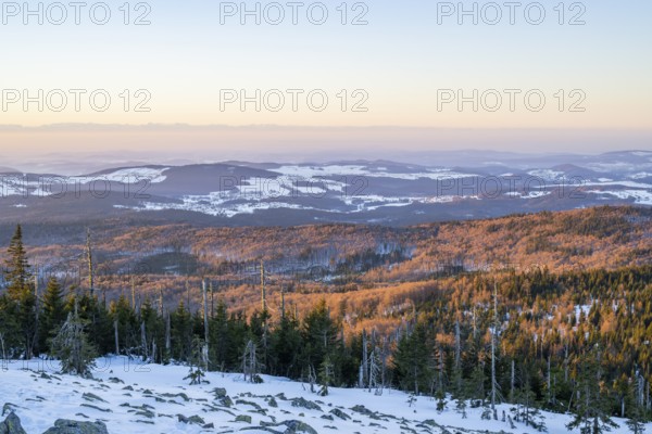 View from Mount Lusen over the hills of the bavarian forest at sunrise in winter, Bavaria, Germany