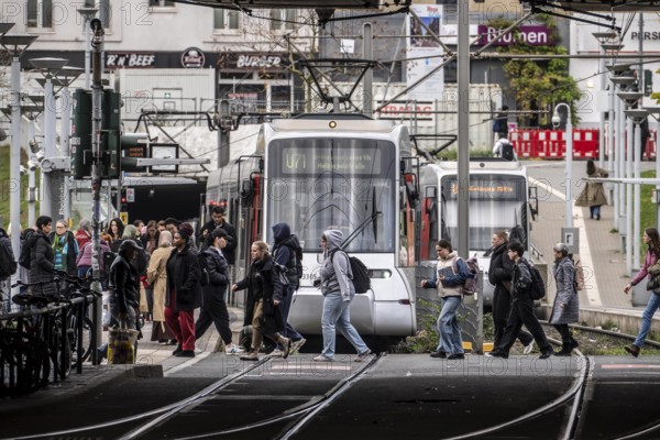 Pedestrians cross the tram tracks, at Düsseldorf-Bilk station, junction of S-Bahn, subway, tram, local bus transport, North Rhine-Westphalia