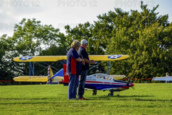 An RC model of a Pilatus PC-21 with advertising for the Swiss watch brand Breitling during a flight demonstration as part of an air show at the Rossfeld in Metzingen-Glems, Baden-Württemberg, Germany, for editorial use only