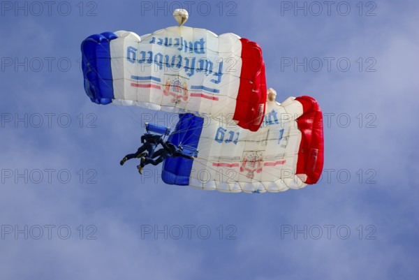 Two parachutists during an aerial acrobatic performance as part of an air show at the Rossfeld in Metzingen-Glems, Baden-Württemberg, Germany, for editorial use only