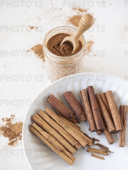 Cinnamon sticks displaying ceylon and cassia varieties with a jar of ground cinnamon powder