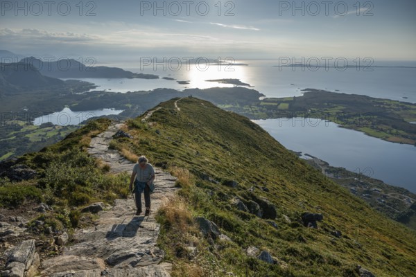 Woman with hiking poles walking up Rørsethornet stone stairs, with 3292 steps one of the longest continuous stone stairs in the world, Sherpat stairs or Midsund stairs or Midsundtrappene, Rørsethornet hike, Otroya or Otrøya island, Møre og Romsdal, Norway