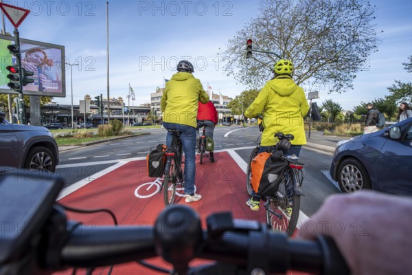 Riding a bike in a bike lane, marked in red to attract the attention of motorists, between 2 lanes, Huyssenallee, in front of Europaplatz, in the city centre of Essen, North Rhine-Westphalia, Germany