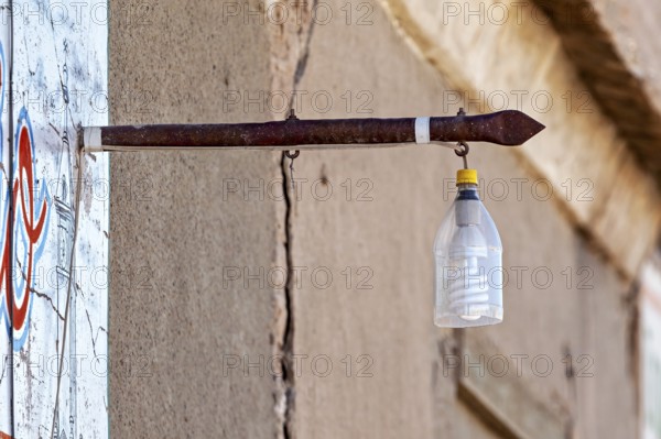 A plastic bottle with a light bulb hangs from an old metal rod on a wall, street lamp in the town of Uyuni in the Salar de Uyuni in Bolivia