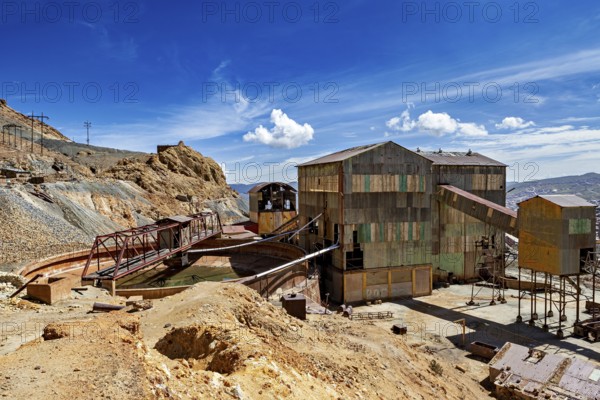 Abandoned industrial plant with rusty buildings against a blue sky and clouds, The silver mines of Potosi Bolivia