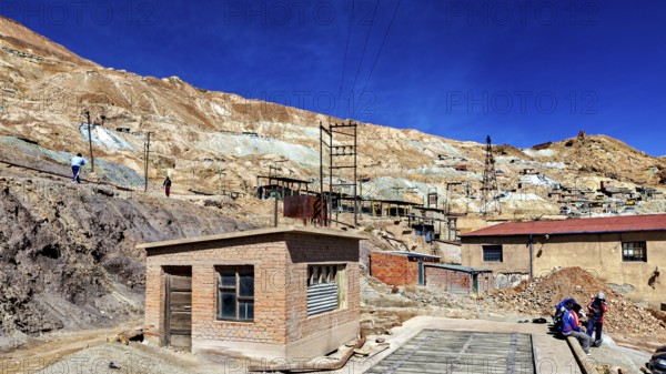Small buildings in a dry, desert-like mining area with people, The silver mines of Potosi Bolivia