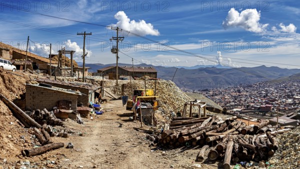 Rustic village scene with huts and mountains in the background under a cloudy sky, The silver mines of Potosi Bolivia