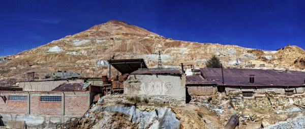 Abandoned buildings on a mountainside with a rocky landscape and a clear blue sky, The silver mines of Potosi Bolivia