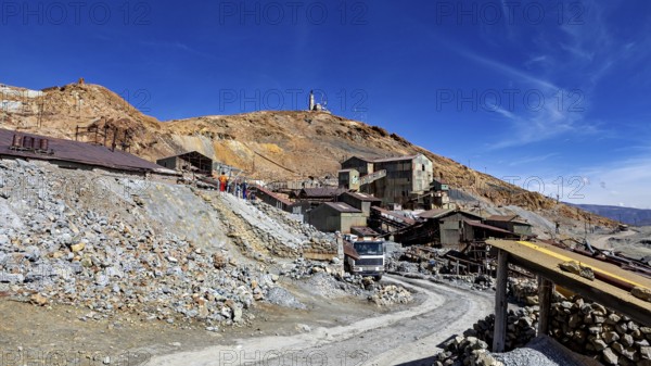 Old industrial complex in a mountainous environment under a clear blue sky with a visible path, The silver mines of Potosi Bolivia