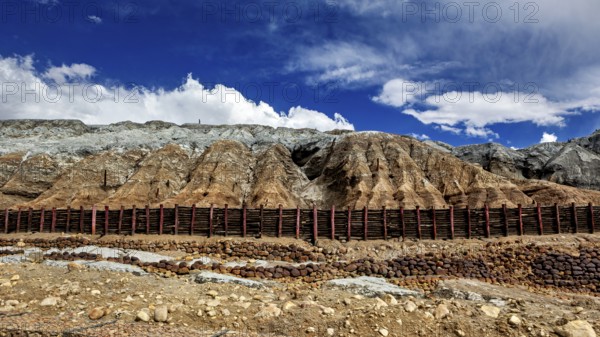 Barren mountain landscape with steep slopes under a blue sky with clouds, spoil heap of the silver mines in Potosi Bolivia