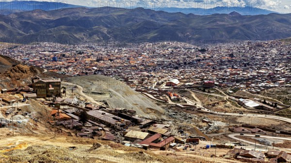Panoramic view of a wide urban landscape surrounded by majestic mountains and clouds, The silver mines of the Cerro Rico silver mountain near Potosi in Bolivia