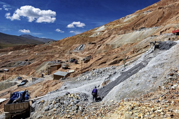 A worker moves on a stony hill with a wide view over the landscape, The silver mines of Potosi Bolivia