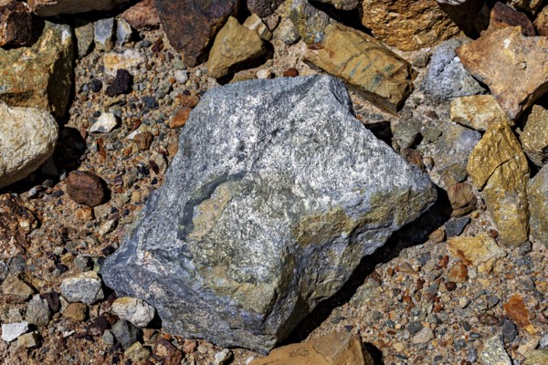 A large, grey rock on a soil of pebbles and earth, the silver ore from the Cerro Rico silver mountain near Potosi in Bolivia