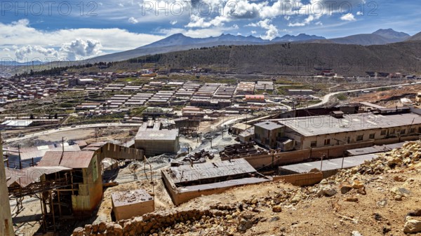 Sweeping views of a valley surrounded by mountains and scattered buildings, The silver mines of Potosi Bolivia
