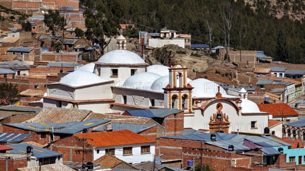 A city view with domes of a church in the foreground, surrounded by brick houses in a mountainous region, The churches of the city of Potosi in Bolivia
