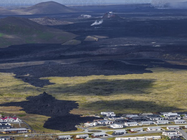Lava, lava field, village, houses, summer, cloudy, sunny, aerial view, volcanic eruption, July 2025, Grindavik, Sundhnúkur crater series, Fagradalsfjall, Reykjanes, Iceland