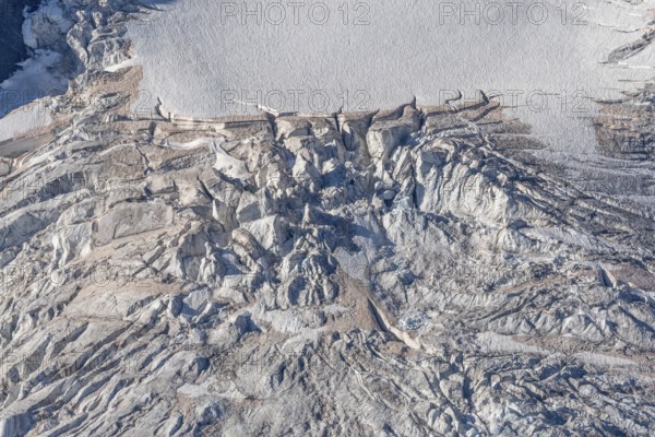 Intricate patterns of ice and rock are showcased in this stunning glacial landscape, revealing the effects of time on the frozen surface. The bright daylight emphasises the textures and colours. Gorner Glacier, Zermatt, Valais, Alps, Swiss