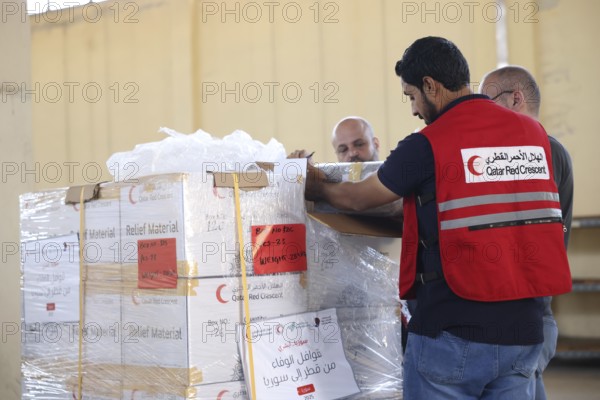 Relief workers unload boxes of medical aid provided by Qatar at Damascus International Airport, part of the humanitarian bridge supporting Syria's recovery and reconstruction after the fall of Bashar al-Assad, Damascus, Damascus, Syria