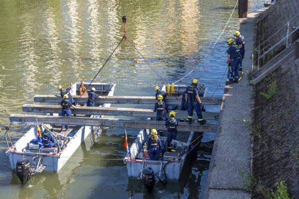 Construction of a multi-purpose pontoon, the specialist group for water hazards, in Düsseldorf, the motorised pontoon can be used as a ferry for people or equipment, as a working platform or bridge, during the major exercise FÜLEX25, lasting several days, of the THW, Technisches Hilfswerk, Landesverband North Rhine-Westphalia, over 3500 volunteers from the 127 North Rhine-Westphalia local associations practise many different deployment scenarios over 4 weekends