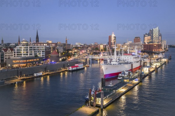 Aerial view of the Landungsbrücken Hamburg (Jan-Fedder-Promenade) at blue hour with Elbe, Cap San Diego and Elbphilharmonie in the background, Hamburg, Germany