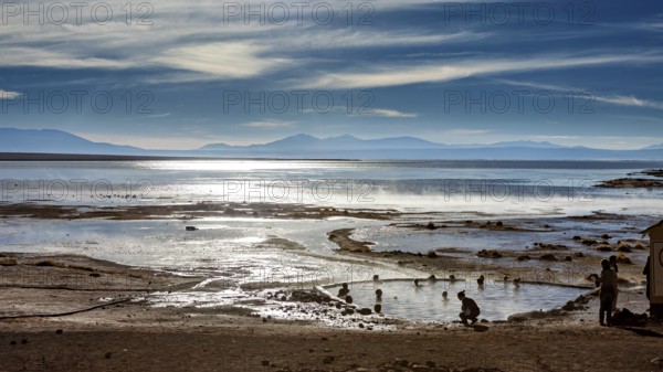 Landscape with hot springs, people and sweeping views of the lake and mountains, The thermal springs of Polques in Bolivia