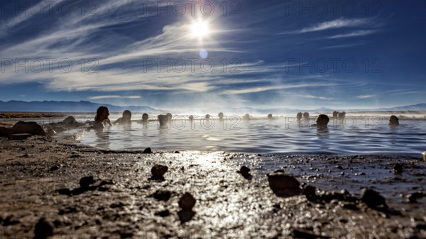 People enjoy hot springs at sunset with a wide sky, The thermal springs of Polques in Bolivia