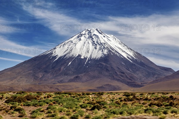 A single snow-covered peak rises majestically into the sky, The landscape with the volcanoes on the Altiplano in Bolivia